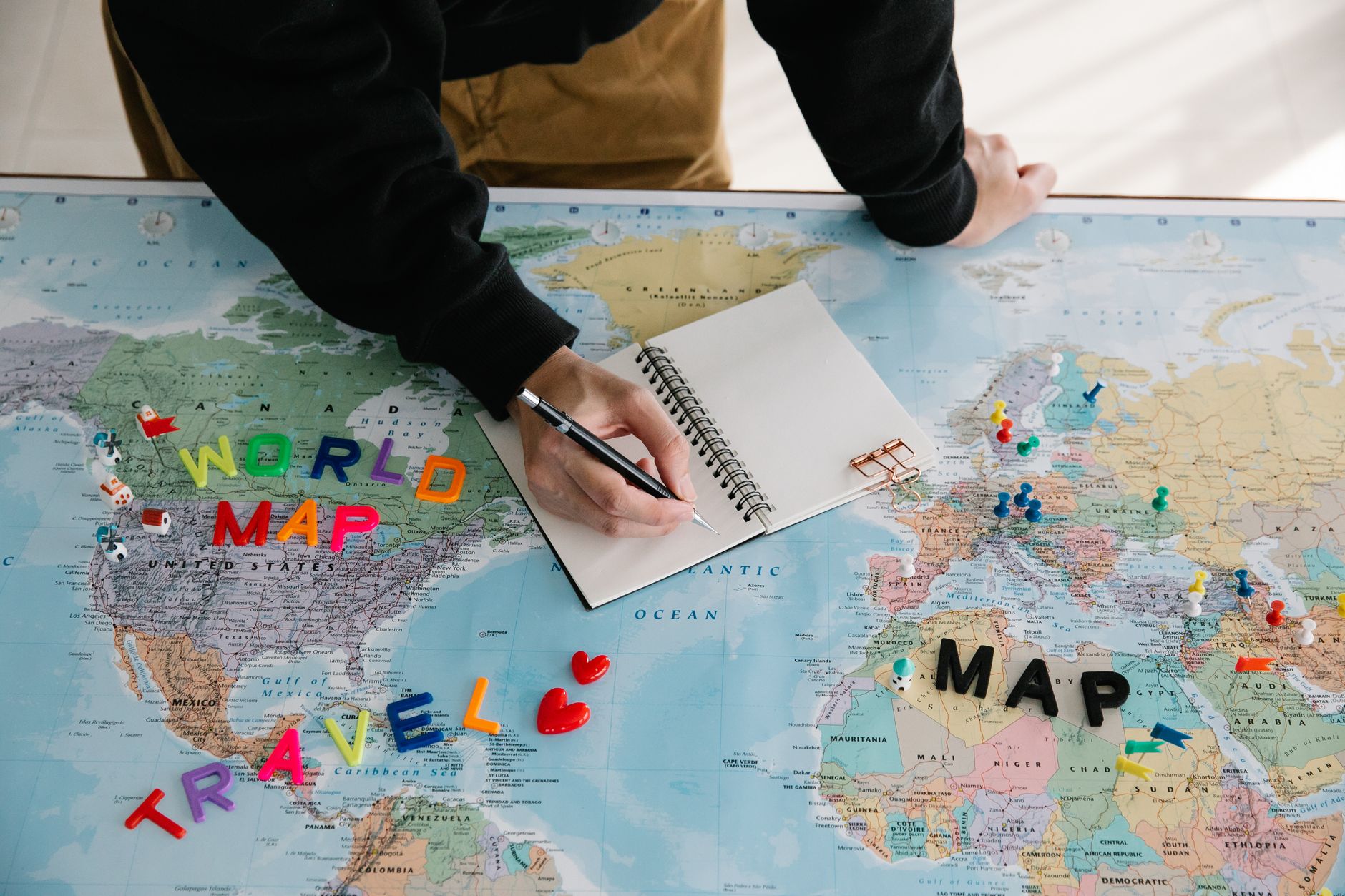 Mapa e itinerário de viagem sendo planejados em uma mesa